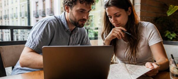 Stel dat vakanties vergelijkt op laptop met papieren checklist in een café