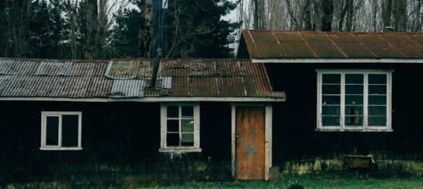 a black house with a rusted metal roof