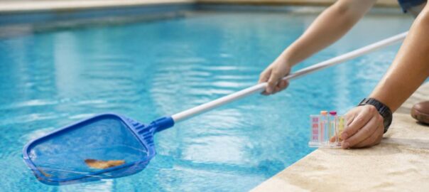 Iemand die een zwembad schoonmaakt en een water testcontrole uitvoert